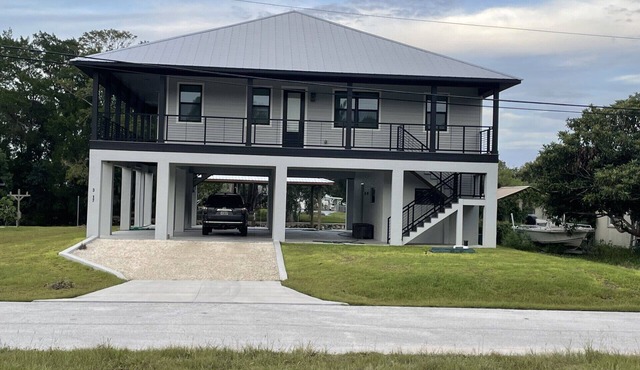 New Stilt Home on quiet canal with wrap around porch.